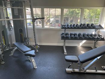 a gym with weights and chairs and a window at Polo Clubs Apartments, Austin, TX 78729